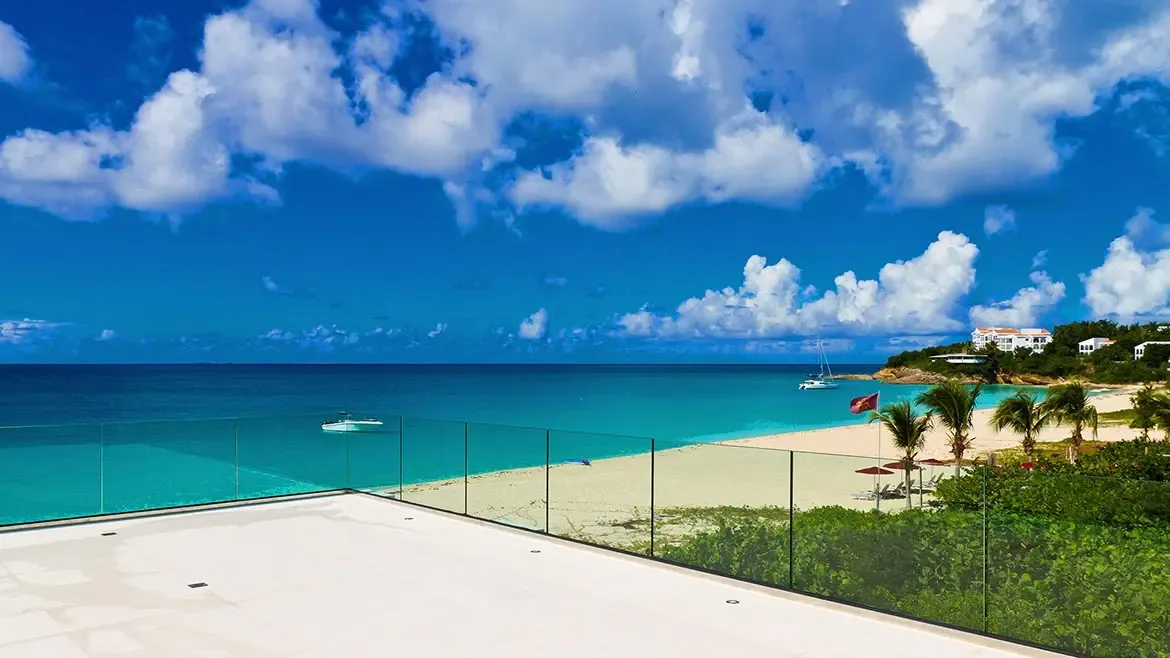 Wake up to breathtaking turquoise ocean views from the expansive modern terrace of this exclusive beachfront villa in Anguilla. This luxury beach house offers direct access to pristine white sands and a private vantage point for watching boats glide across the Caribbean Sea.
