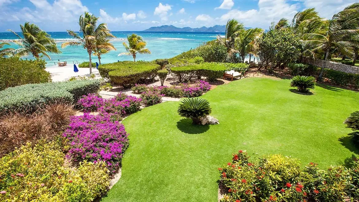 Experience pure Caribbean bliss in the vibrant, landscaped gardens of Villa Indigo, featuring panoramic ocean views and lush tropical greenery. This meticulously maintained beachfront estate offers a serene outdoor oasis, providing the perfect setting for a luxurious and tranquil island getaway in Anguilla.