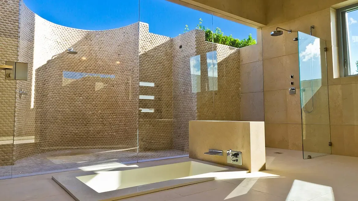 Indulge in ultimate relaxation within this spa-inspired bathroom, featuring a deep soaking tub and a stunning indoor-outdoor shower with natural pebble walls. This luxurious Anguilla beach house retreat offers a seamless blend of modern architecture and tropical serenity for an unforgettable getaway.