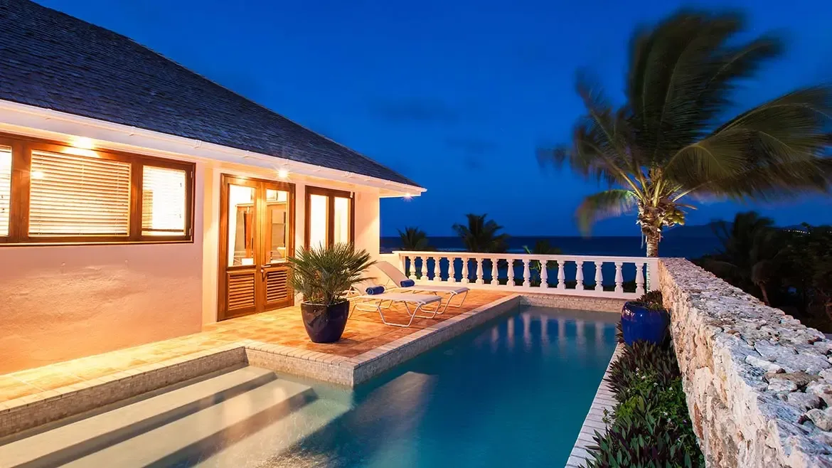 Relax on the private pool terrace of Villa Indigo, a luxury Anguilla vacation rental offering breathtaking sunset views over the Caribbean Sea. This elegant estate features seamless indoor-outdoor living, perfect for a high-end tropical getaway.