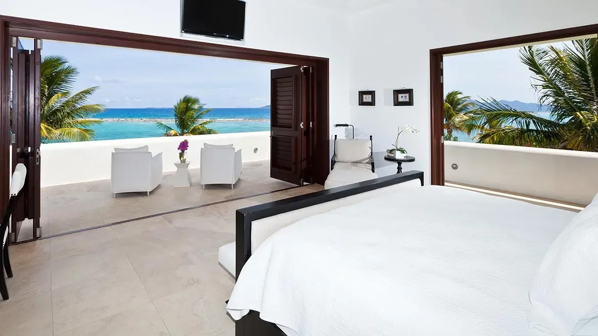 This oceanfront master bedroom frames panoramic sea views through expansive folding doors, bringing the landscape directly into the suite. Clean lines, natural light, and a private terrace create a polished luxury bedroom presentation.