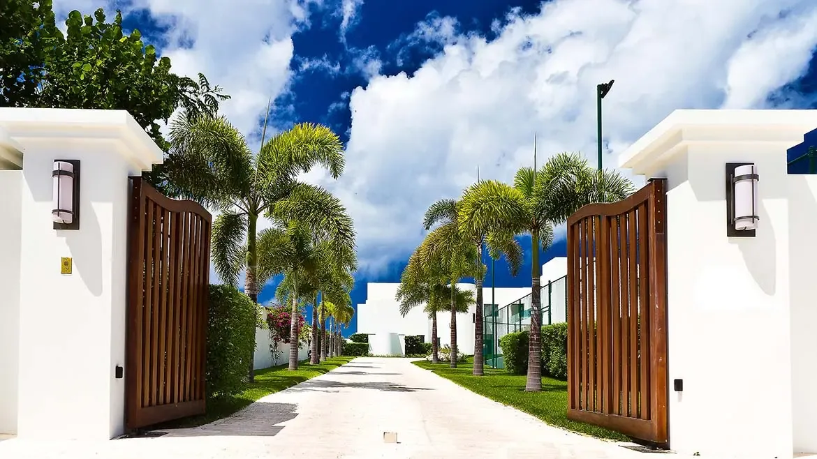 Welcome to the grand entrance of this stunning Anguilla luxury villa, featuring a private palm-lined driveway and sleek modern architecture. Experience the ultimate Caribbean escape in this exclusive beach house, offering unparalleled privacy and elegance for a world-class vacation rental experience.