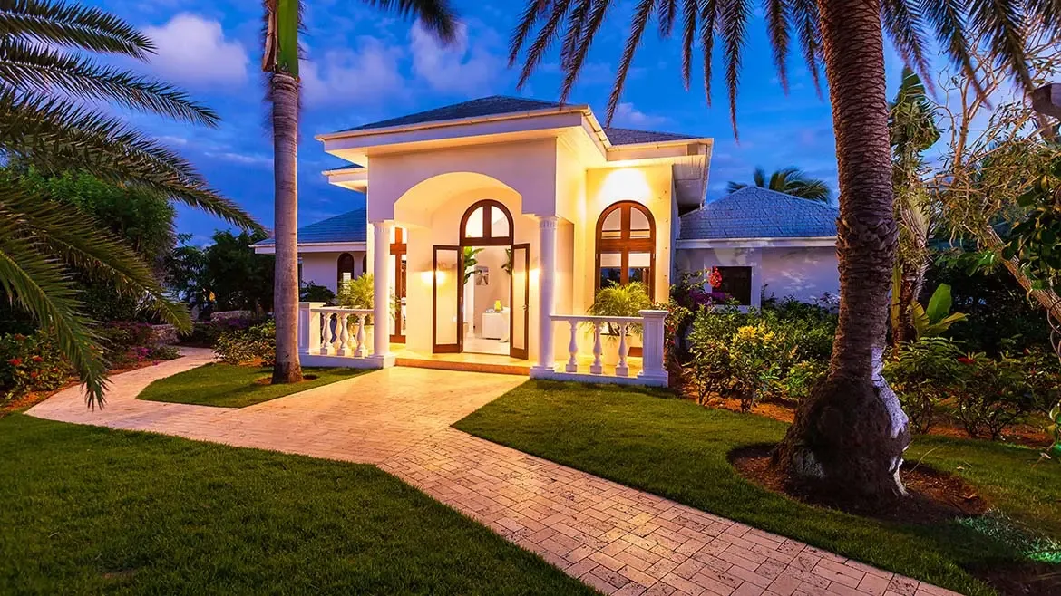 Experience ultimate Caribbean luxury at Villa Indigo, an exquisite private estate nestled in the lush tropical landscapes of Anguilla. This stunning villa features elegant arched entryways and beautifully manicured gardens, providing a sophisticated and serene oasis for your next high-end island getaway.
