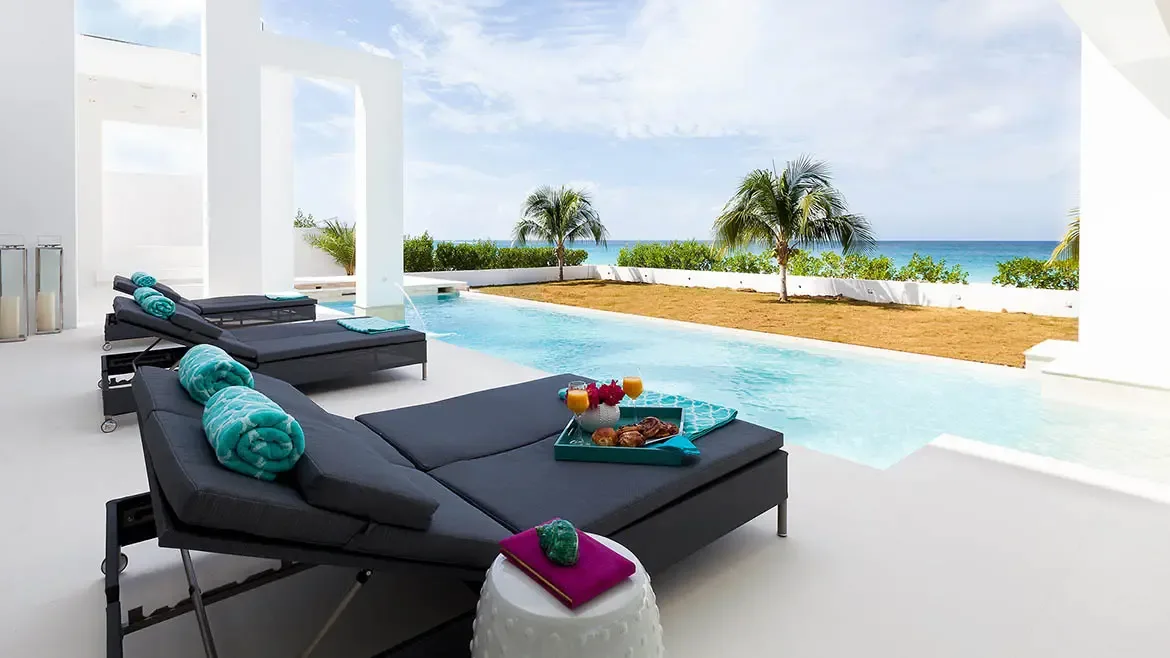 Experience ultimate relaxation at this ultra-modern Anguilla beach house, featuring a stunning infinity pool overlooking the turquoise Caribbean Sea. The spacious outdoor terrace is elegantly furnished with plush lounge beds, designer accents, and panoramic views, perfect for a high-end luxury villa retreat.