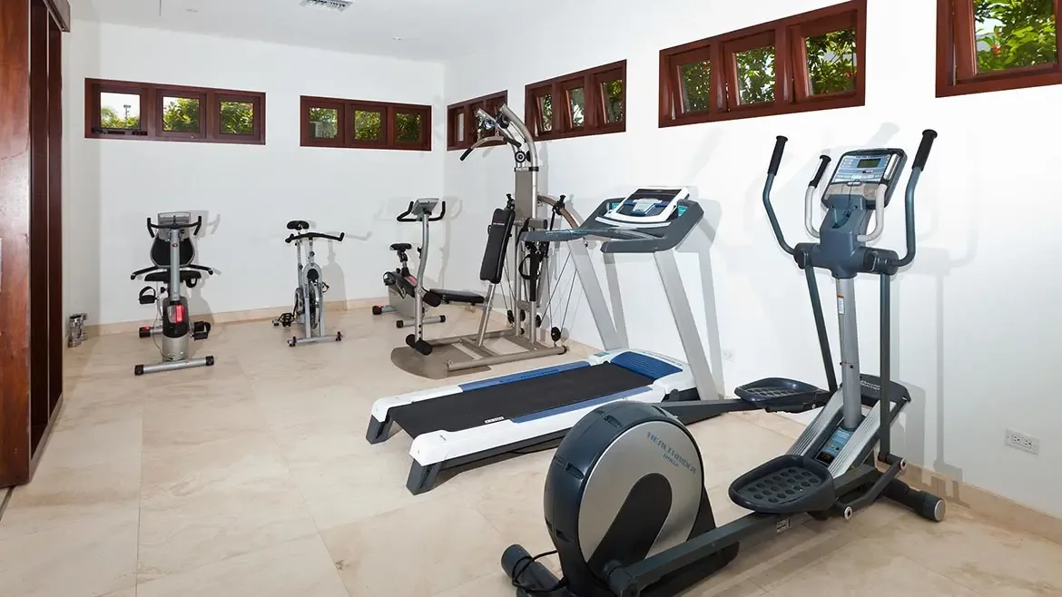The dedicated fitness room at Le Bleu Villa is bright, airy, and thoughtfully equipped for private workouts. This amenity photo supports the villa's positioning as a fully serviced luxury retreat in Anguilla.