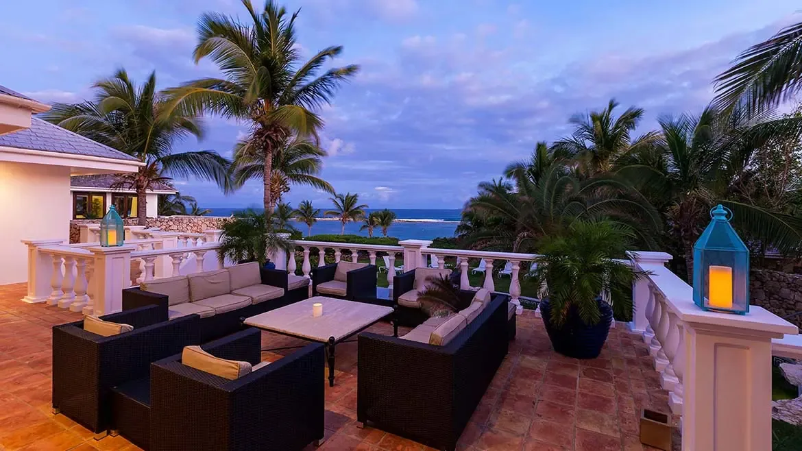 Experience unparalleled luxury at Villa Indigo, featuring an expansive terrace with plush seating and stunning panoramic ocean views in Anguilla. This elegant outdoor living space is perfect for enjoying twilight cocktails and the gentle Caribbean breeze in a private, tropical setting.