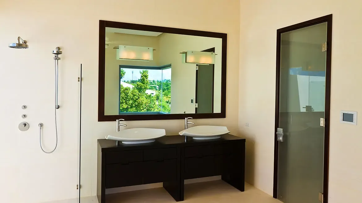 Experience ultimate relaxation in the modern ensuite bathroom of this luxury Anguilla beach house rental, featuring sleek double vessel sinks and premium fixtures. The spacious design and contemporary finishes create a spa-like atmosphere for your Caribbean getaway.