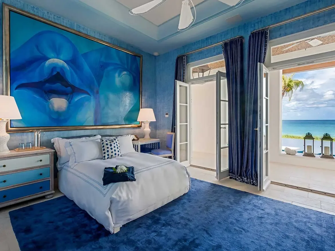 Wake up to breathtaking turquoise vistas in this masterfully designed cerulean-themed bedroom at a premier luxury villa in Anguilla. This light-filled suite features contemporary blue accents, original abstract art, and seamless indoor-outdoor living with direct access to a private balcony overlooking the Caribbean Sea.