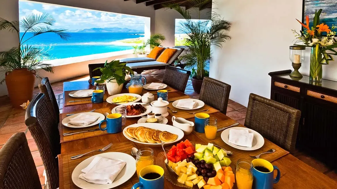 The club room at Zenaida Estate offers a refined space for entertainment, featuring a billiards table, wet bar, and panoramic garden views.