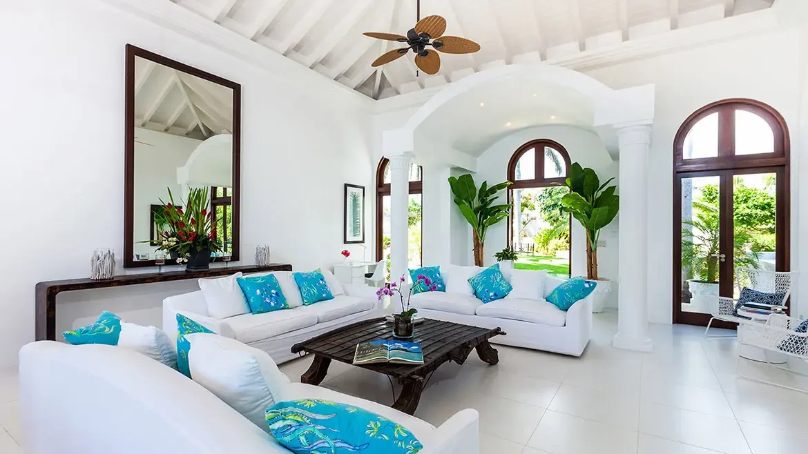 Experience the ultimate in Caribbean luxury at Villa Indigo in Anguilla, featuring a bright and airy living area with soaring vaulted ceilings and vibrant turquoise accents. This elegant space offers a seamless indoor-outdoor flow, making it the perfect sanctuary for a high-end tropical villa rental getaway.