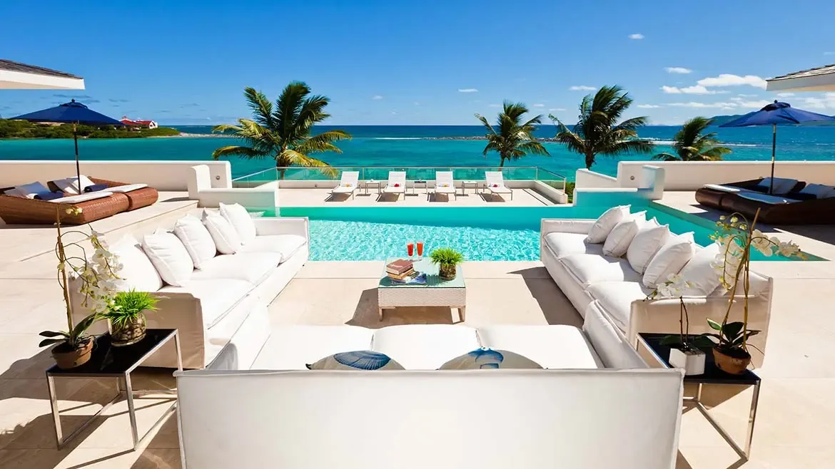 The infinity pool and sunlit outdoor lounge at Le Bleu Villa create a refined setting for entertaining above the Caribbean Sea. This photo captures the villa's signature combination of comfort, privacy, and panoramic ocean views.