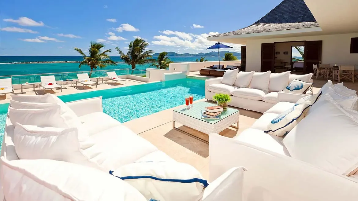 This expansive beachfront terrace combines a private pool, generous lounge seating, and sweeping ocean views for a quintessential Anguilla villa experience. The composition speaks directly to travelers seeking privacy and elevated outdoor living.