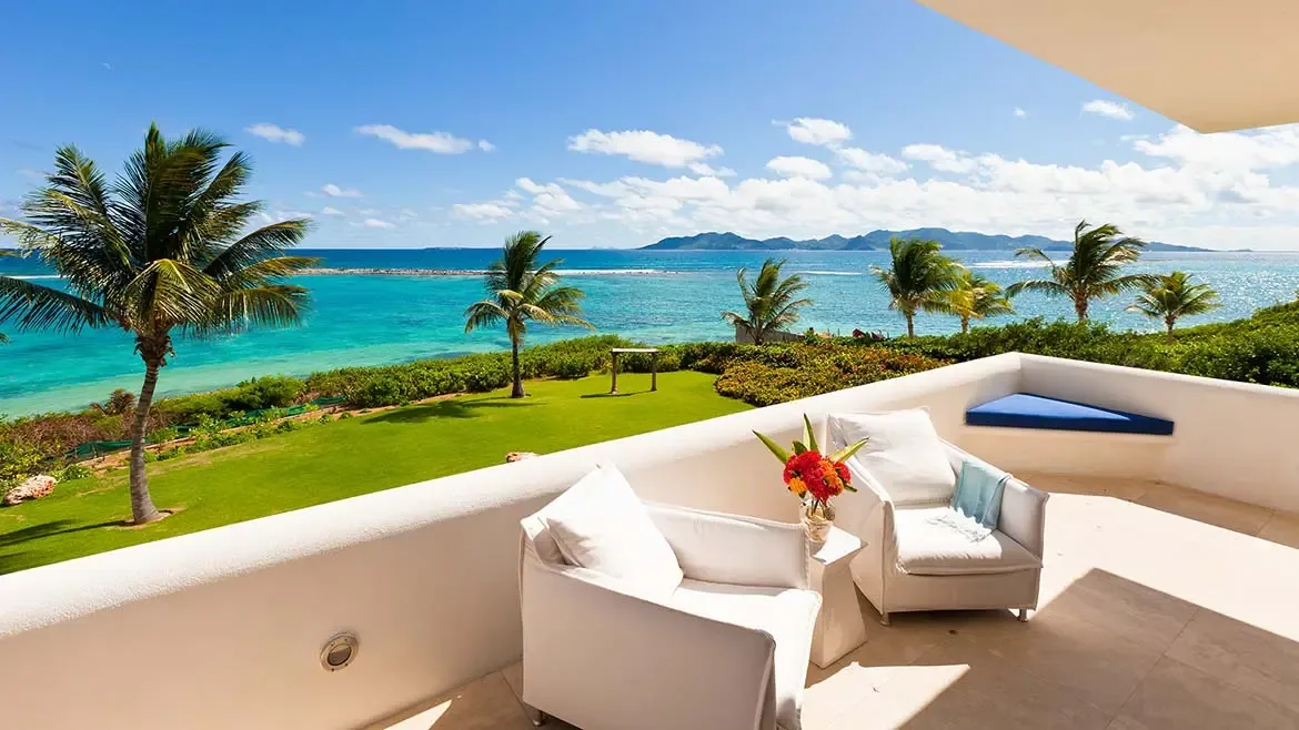 From this elevated balcony, Le Bleu Villa enjoys open views across palm trees and the sparkling Caribbean Sea. The image captures the peaceful, sun-drenched atmosphere that defines luxury island living in Anguilla.