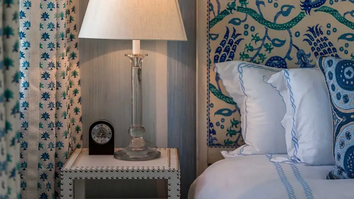 This elegantly appointed bedroom at Cerulean Villa features curated designer textiles, a bespoke studded nightstand, and calming coastal tones. Every detail is meticulously crafted to provide a sophisticated and serene sanctuary for the ultimate luxury Caribbean escape.