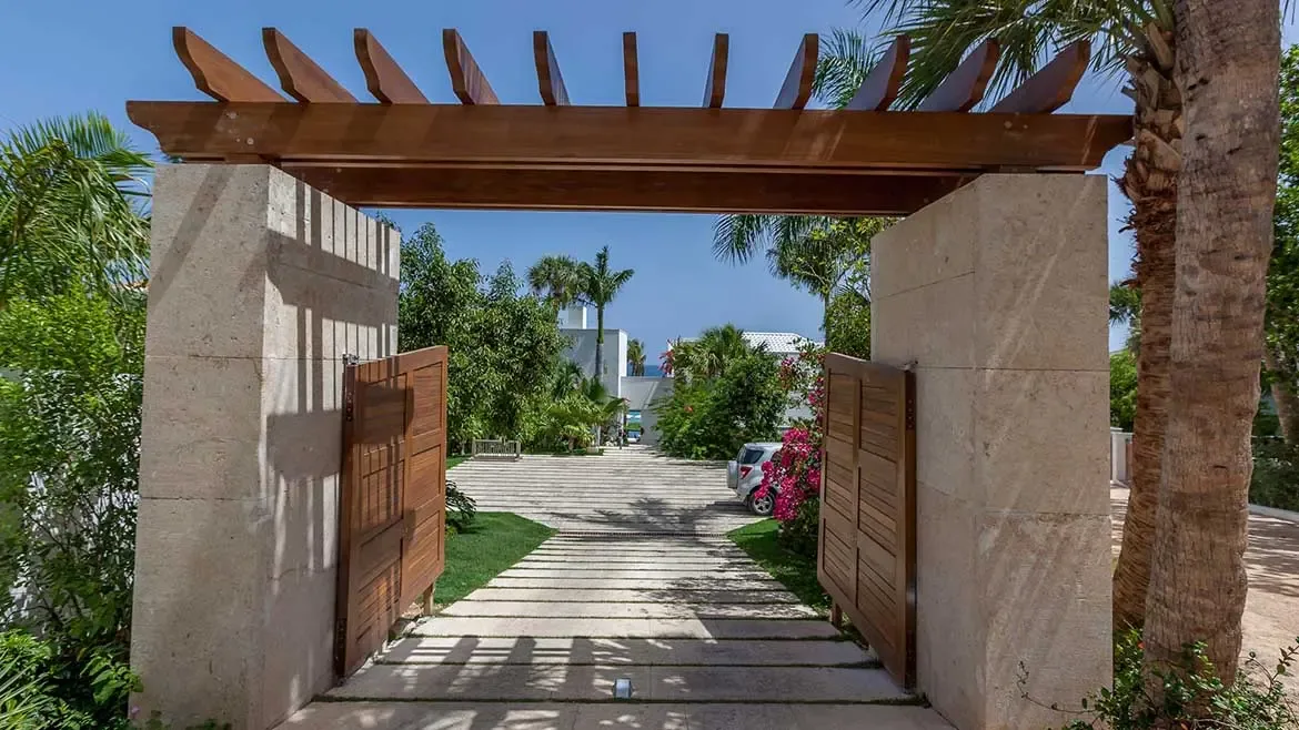 The grand entrance of Cerulean Villa in Anguilla sets a tone of luxury and exclusivity with its elegant stone pillars and timber pergola. Guests are welcomed into a secluded tropical paradise through beautifully manicured grounds, making it the ultimate destination for a high-end Caribbean villa rental.