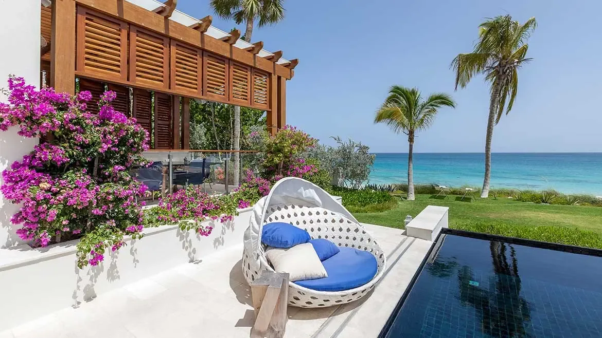Experience unparalleled luxury at Villa Cerulean in Anguilla, featuring a sleek infinity pool that overlooks the mesmerizing turquoise Caribbean Sea. Relax on the elegant terrace amidst vibrant bougainvillea and lush tropical palms for the ultimate island retreat.
