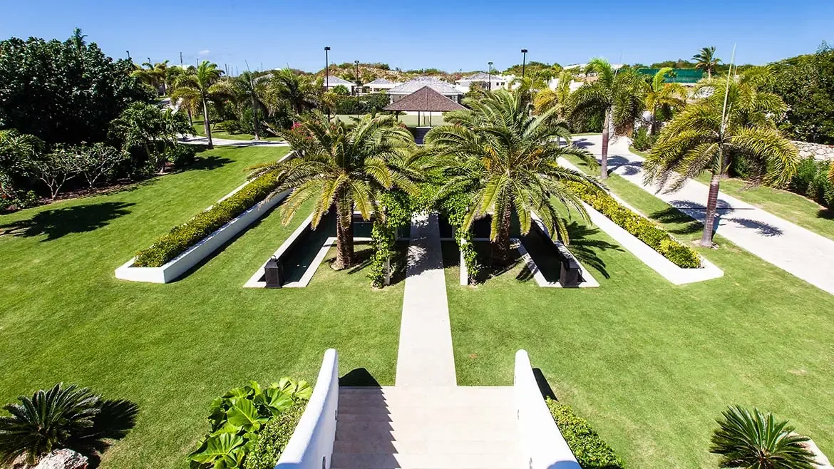 This elevated garden view highlights Le Bleu Villa's symmetrical landscaping, palm-lined grounds, and thoughtful estate planning. It serves as a strong closing image for the gallery, reinforcing the scale and polish of this premier Anguilla property.