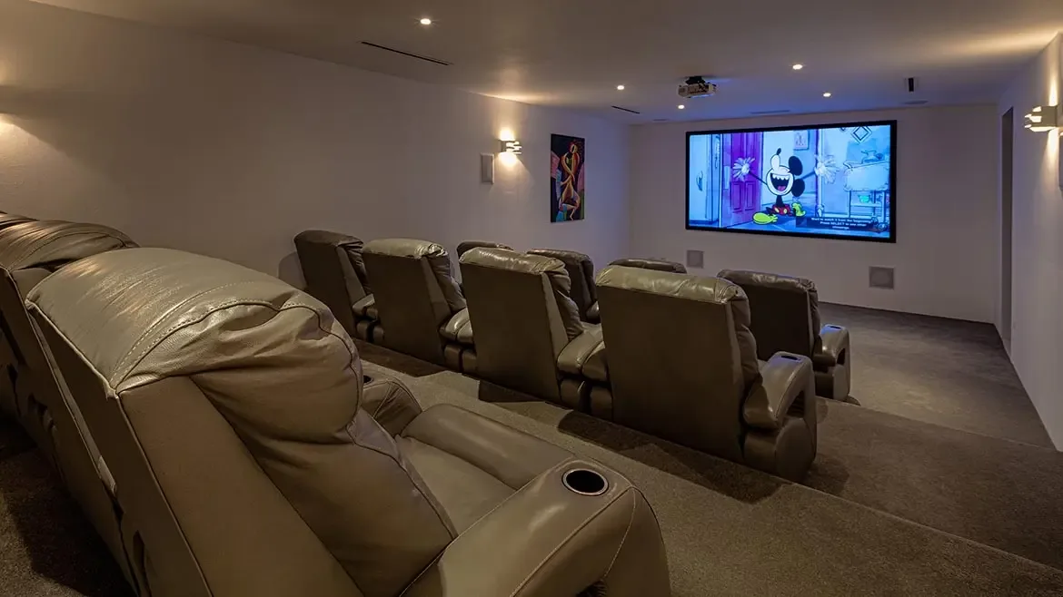 Indulge in the ultimate movie night within this luxury Anguilla beach house featuring a state-of-the-art private cinema room. The space is elegantly appointed with tiered leather reclining seats and premium audiovisual equipment for an immersive entertainment experience.