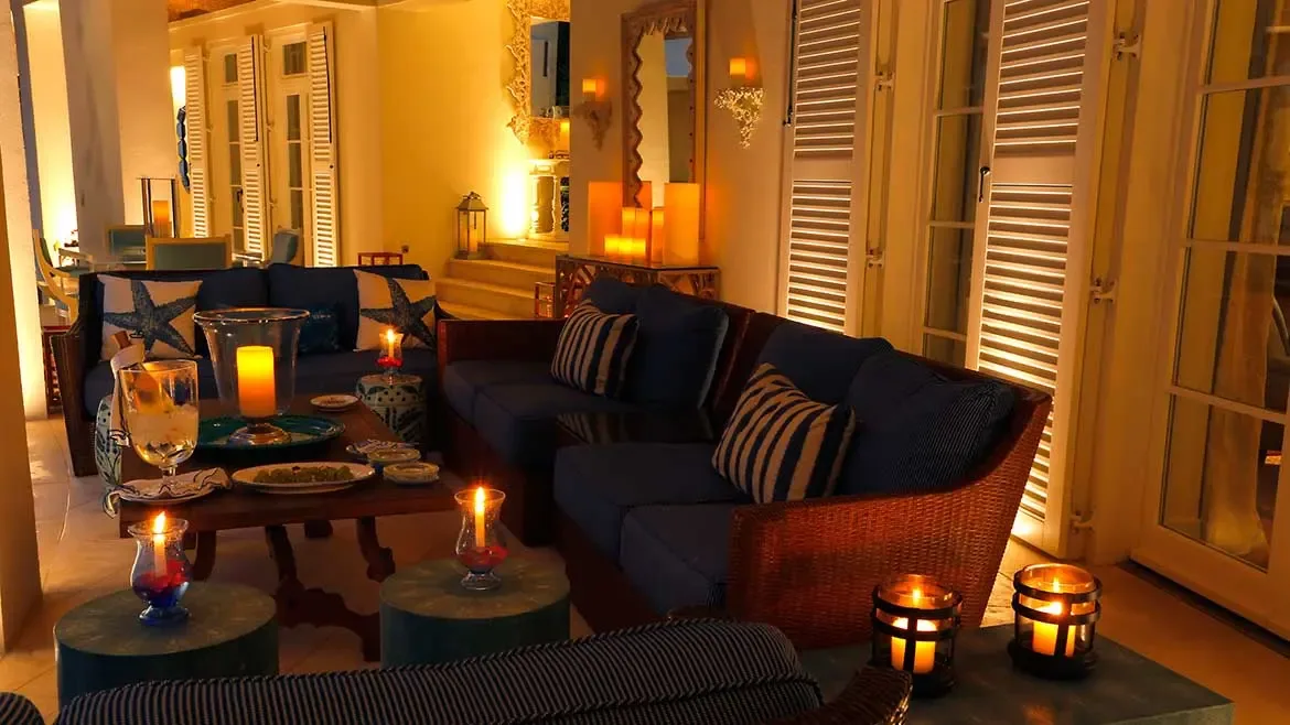 Experience the epitome of Caribbean elegance in this candlelit lounge at Cerulean Villa, featuring plush navy seating and a warm, sophisticated ambiance. This luxury beachfront estate in Anguilla offers the perfect setting for intimate evening gatherings and high-end tropical relaxation.