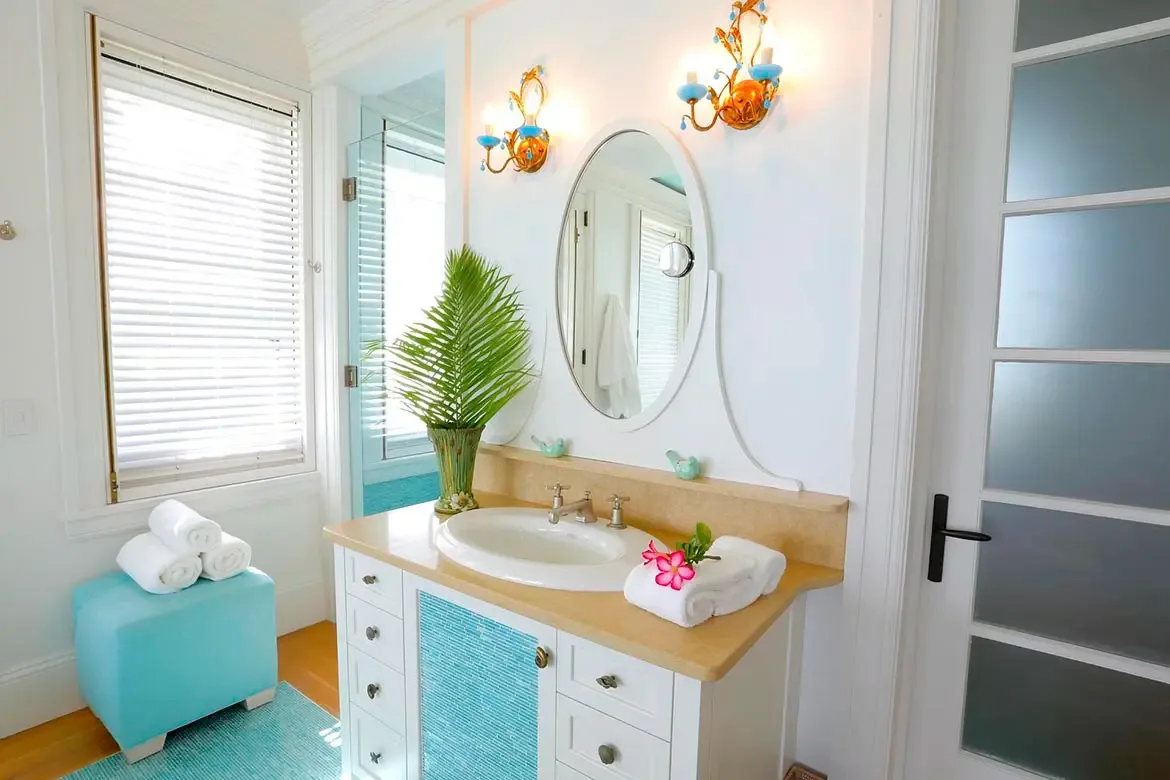 Experience pure tropical serenity in a Villa Santosha guest suite, where soft turquoise hues and a majestic four-poster bed invite total relaxation overlooking the pristine shores of Long Bay.