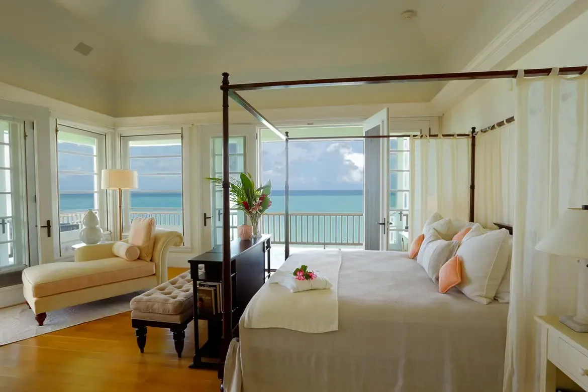 Indulge in the refined tropical elegance of the bathrooms at Villa Santosha, where hand-carved details and luxurious dark wood vanities create a serene sanctuary within your Long Bay retreat.