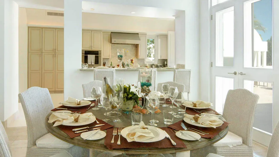 Elegant round dining table set for a meal, located adjacent to the open-concept kitchen.