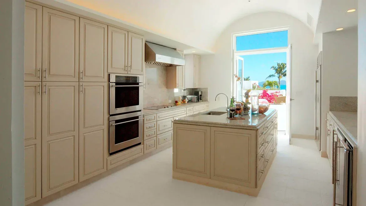 High-end gourmet kitchen with cream-colored cabinetry, stainless steel ovens, and a large center island.