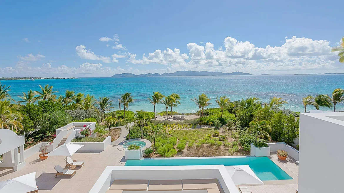Panoramic view from Villa Arushi overlooking the turquoise ocean, tropical gardens, and distant islands in Anguilla.