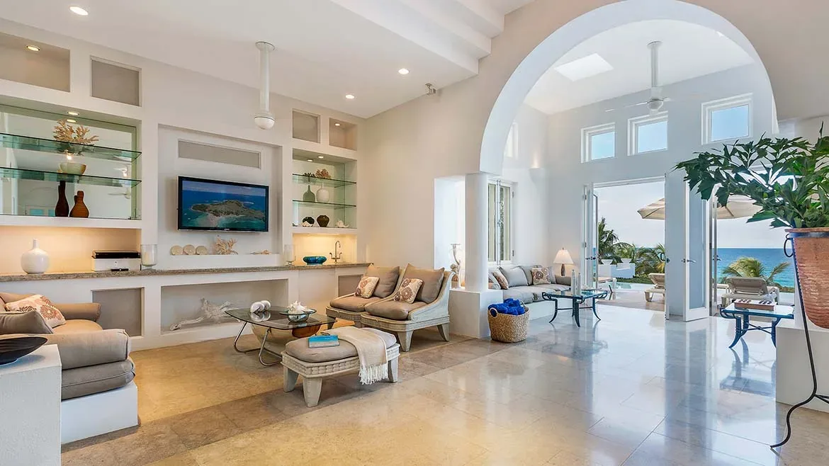 Spacious open-concept living room with arched ceilings, contemporary furniture, and views of the ocean.