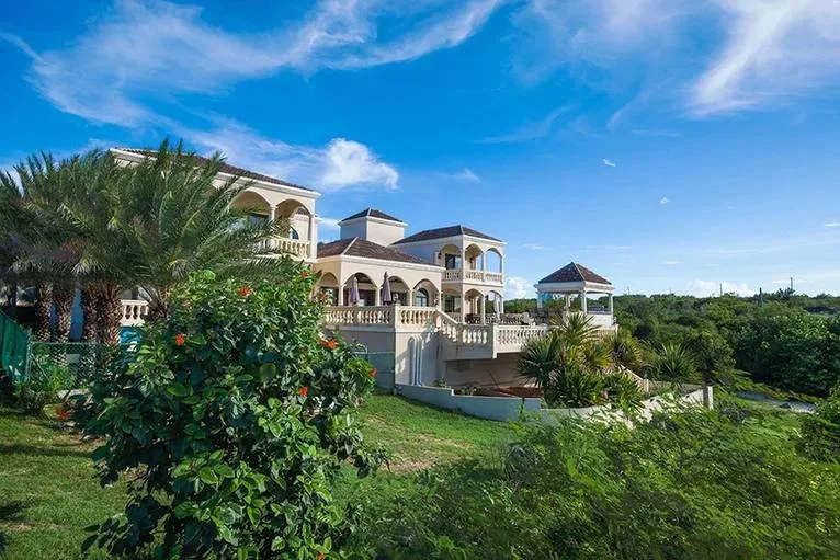 Elevated view of Villa Sandcastle featuring tiered terraces, lush tropical gardens, and terracotta rooflines.