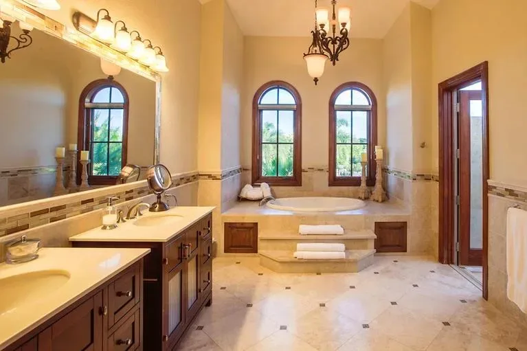 Luxurious master bathroom with double vanities and a large sunken soaking tub.