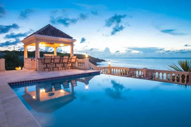 Evening view of the swimming pool and illuminated gazebo at Villa Sandcastle in Anguilla.