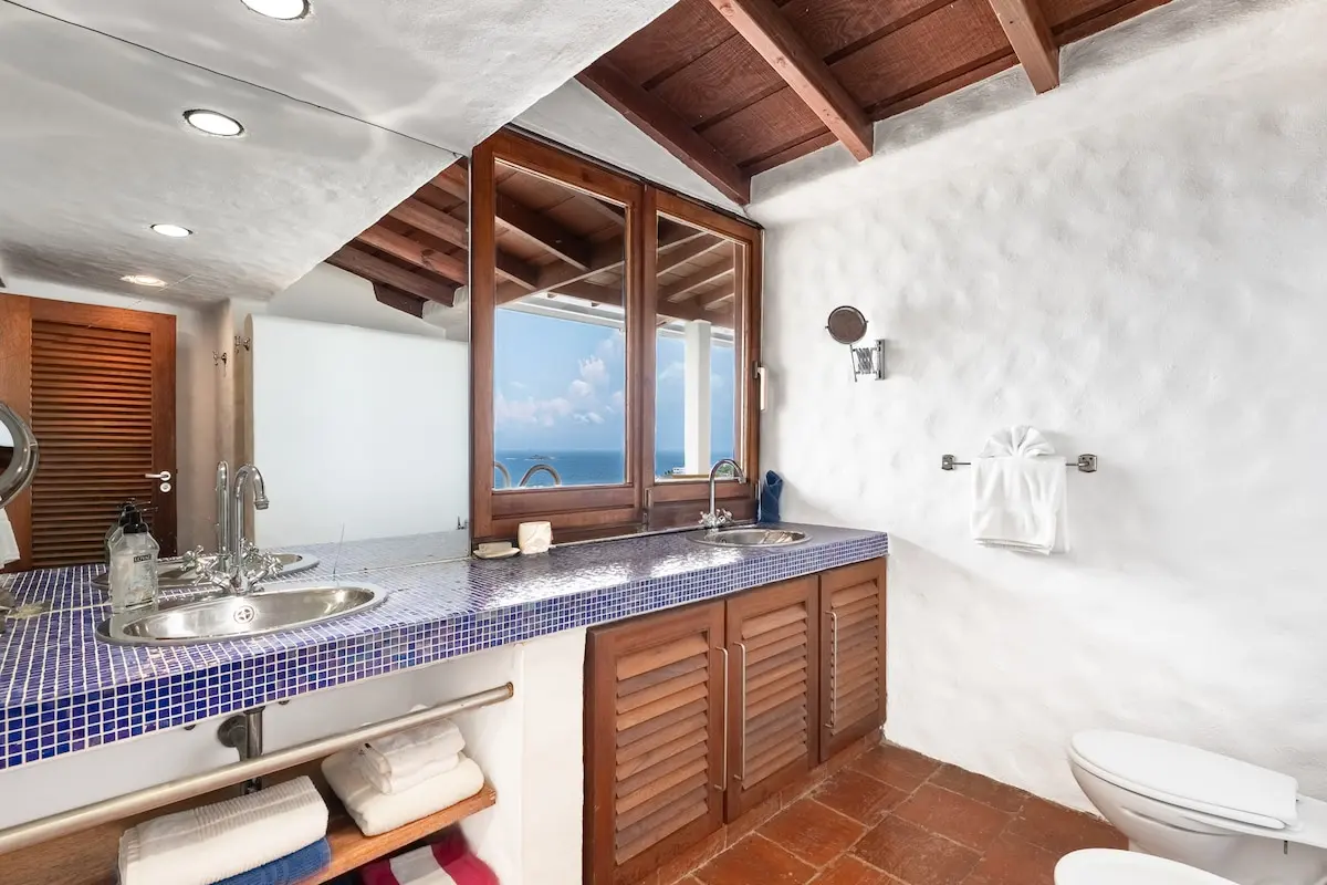 Spacious bathroom with double vanity and ocean view.