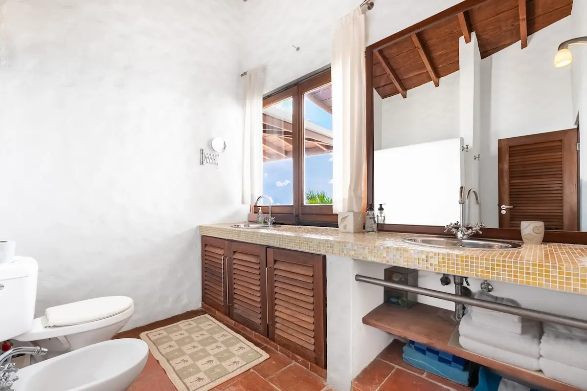 Bright bathroom with wood vanity and ocean view.