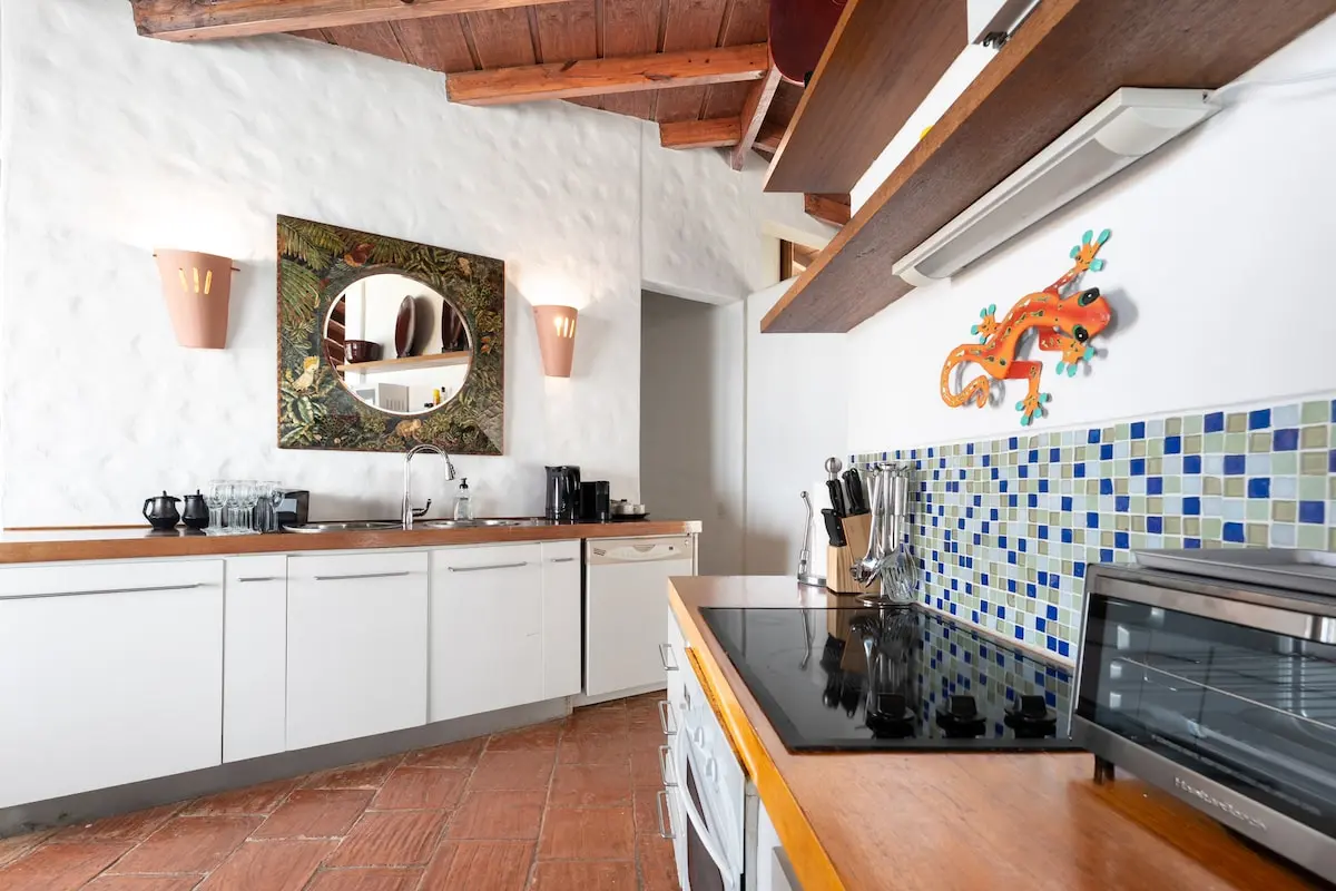 Kitchen with blue tile backsplash and ocean-facing windows.
