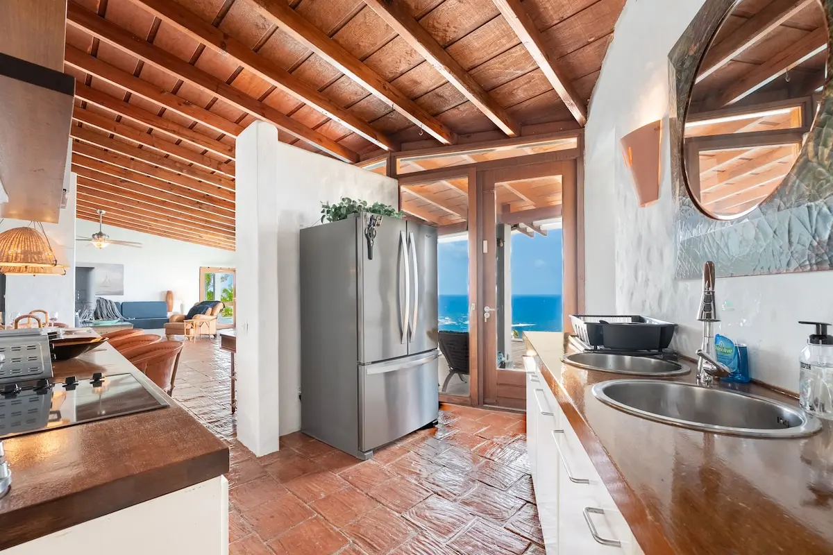 Fully equipped kitchen with refrigerator and wood counters.