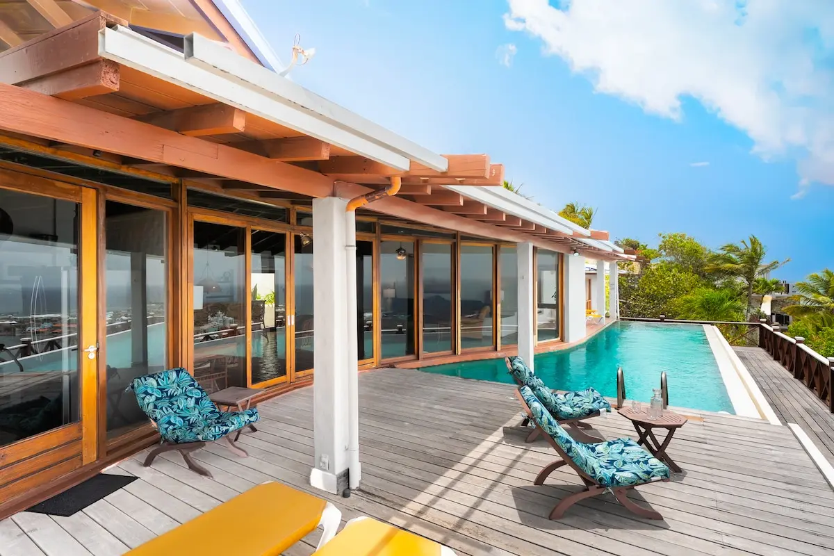 Pool deck with sun loungers beside the villa.