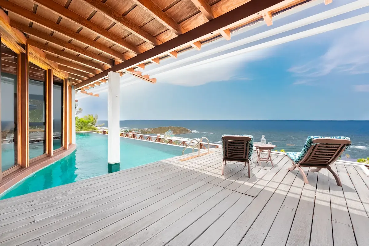 Private pool deck with loungers and a sweeping sea view.