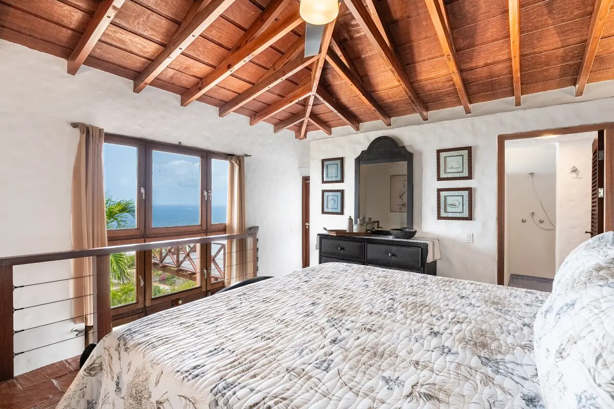 Primary bedroom opening toward the ocean-view balcony.