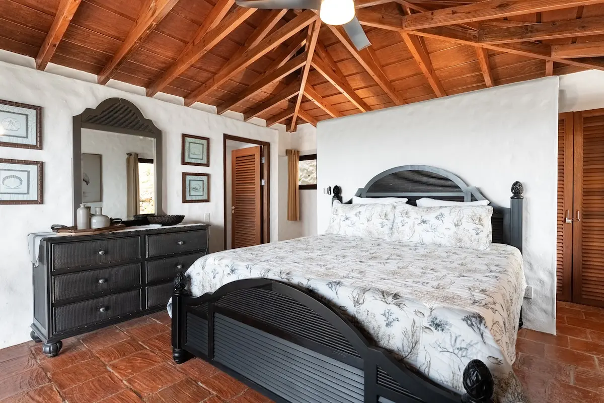 King bedroom with vaulted ceiling and Caribbean-style furnishings.