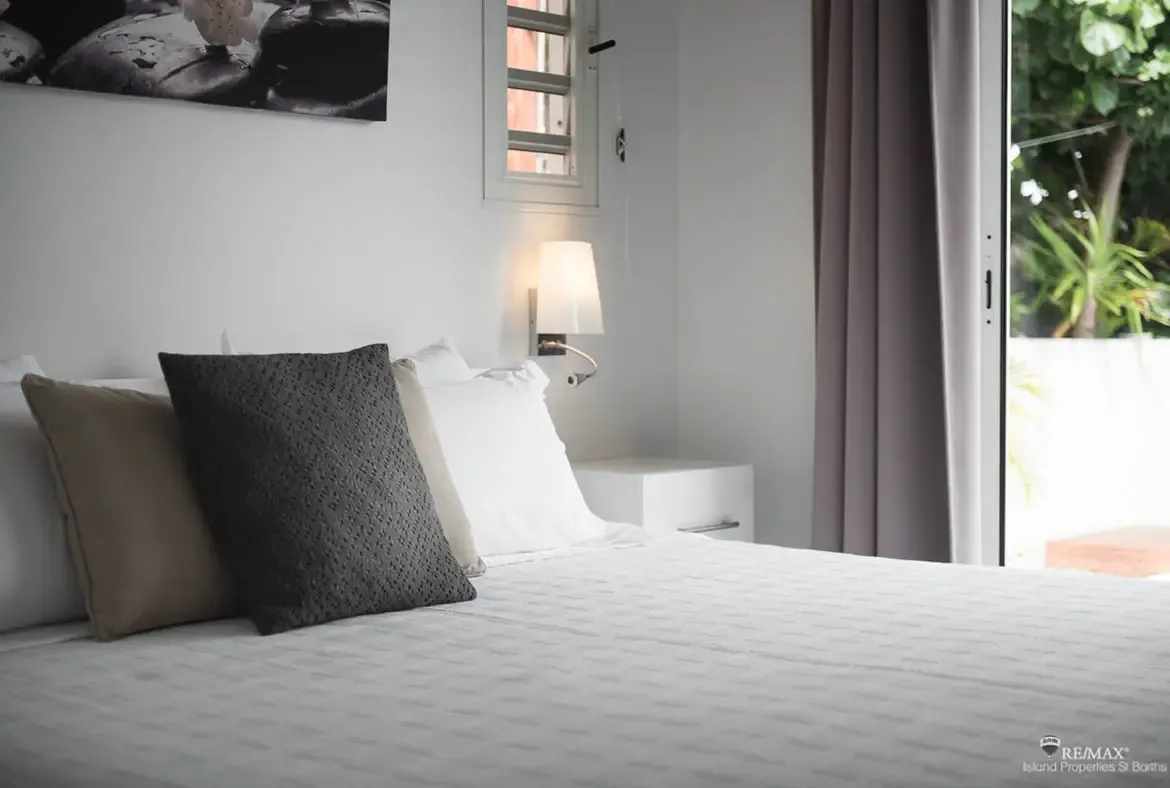 A peaceful bedroom with garden views through sliding doors — natural light and tropical breezes await.