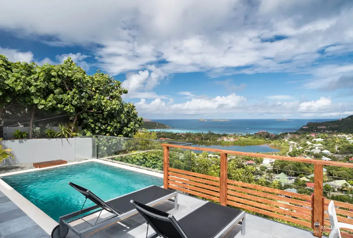 Your private pool terrace overlooks the Caribbean — relax on loungers as sailboats drift across the horizon.