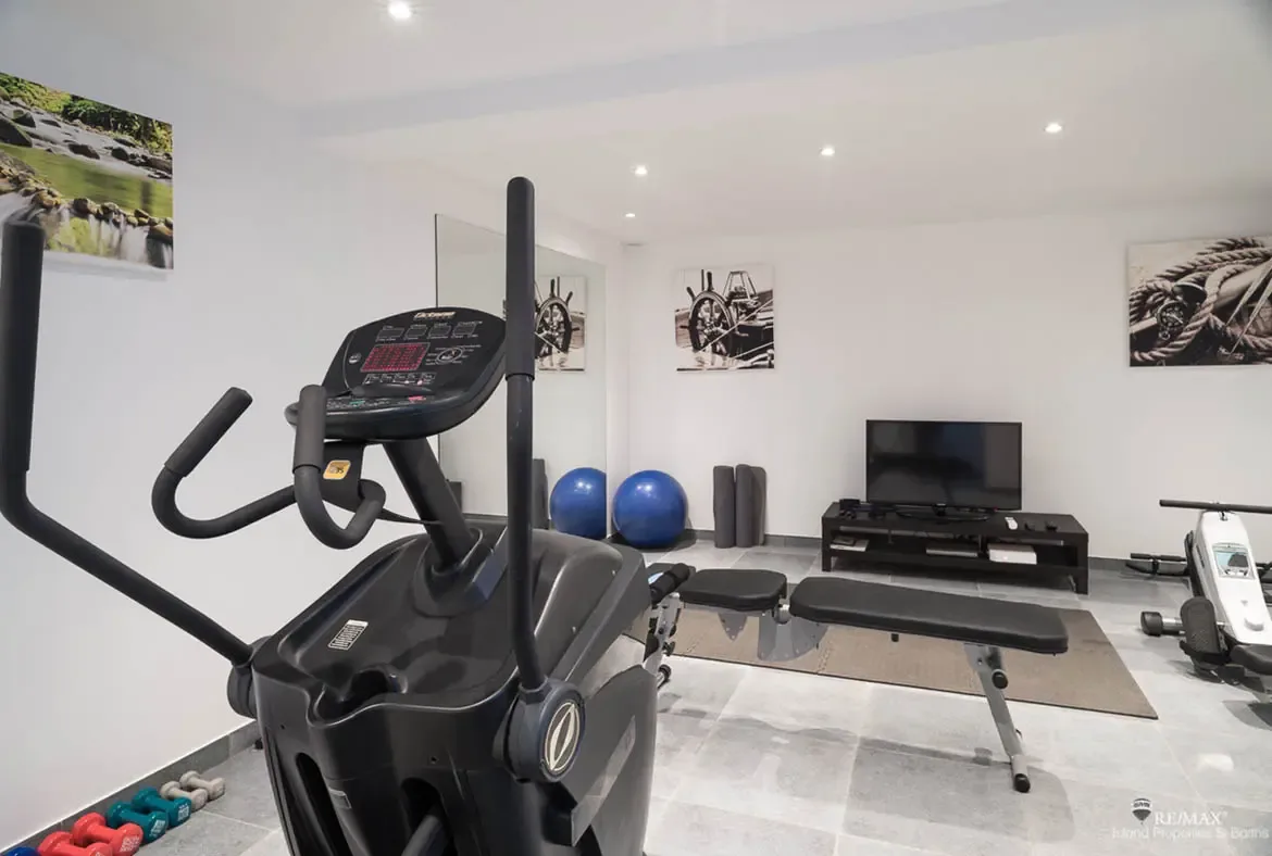 A fully equipped private gym with elliptical, weights, and exercise balls — stay active during your Caribbean retreat.