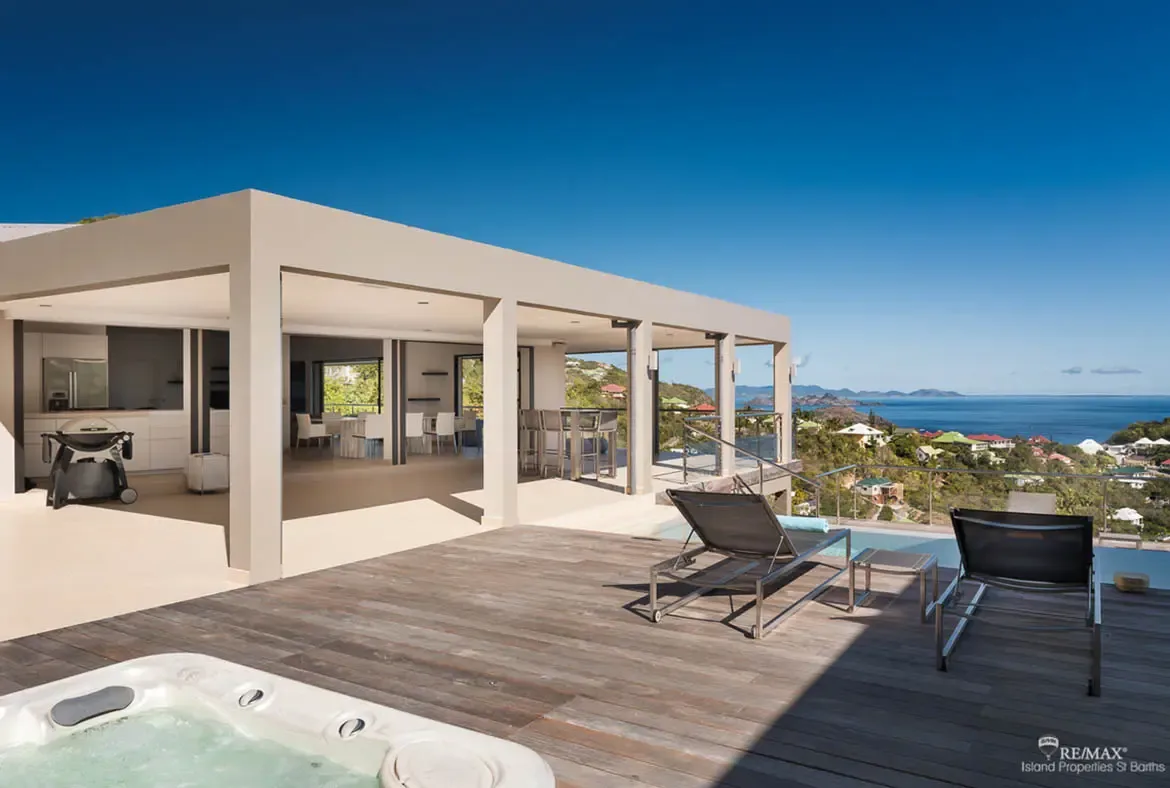 A bubbling hot tub, open-air kitchen, dining pavilion, and infinity-edge deck all come together in one dramatic hillside setting. With loungers facing the ocean and green valleys below, this is the kind of outdoor setup guests remember long after the trip ends.
