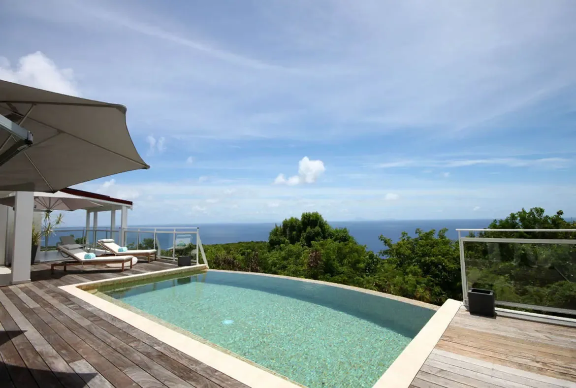 A crystal-clear infinity pool serves as the centerpiece of Villa Dasha's outdoor luxury.