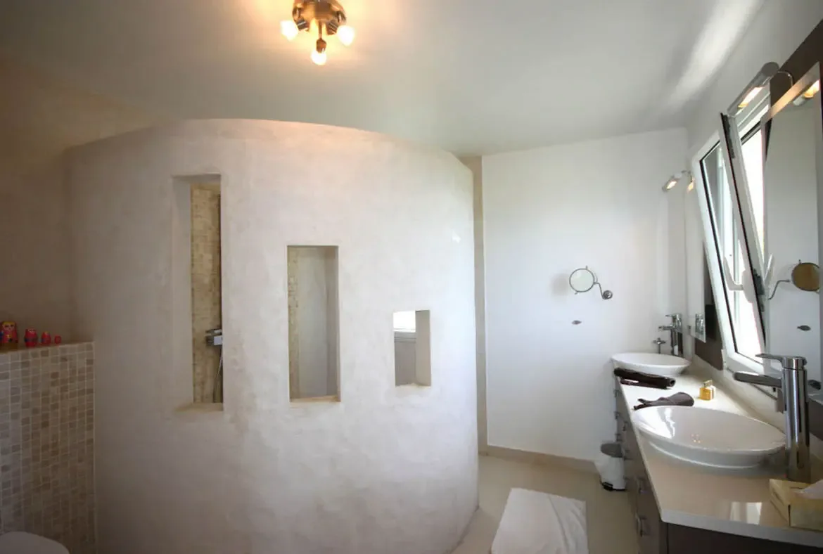 Contemporary design meets organic textures in a spa-like ensuite featuring a unique architectural shower.