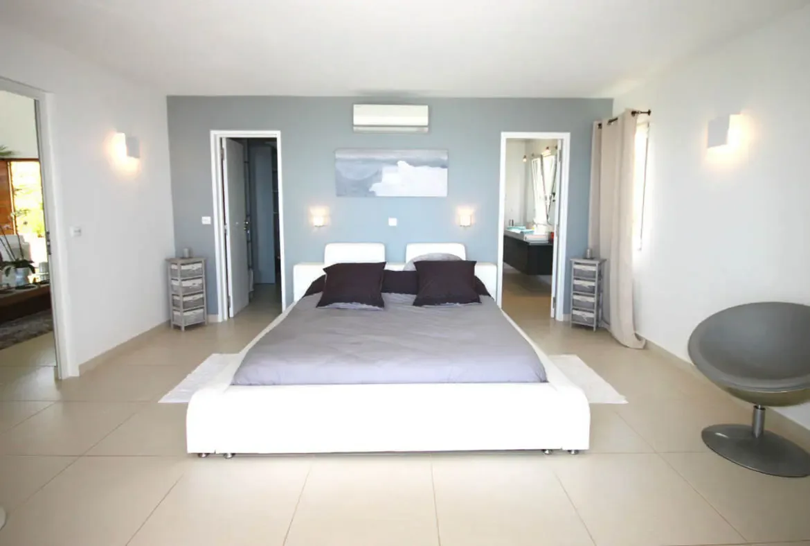 Rest in total tranquility within this minimalist suite, where cool blue accents and soft lighting create a serene island sanctuary.