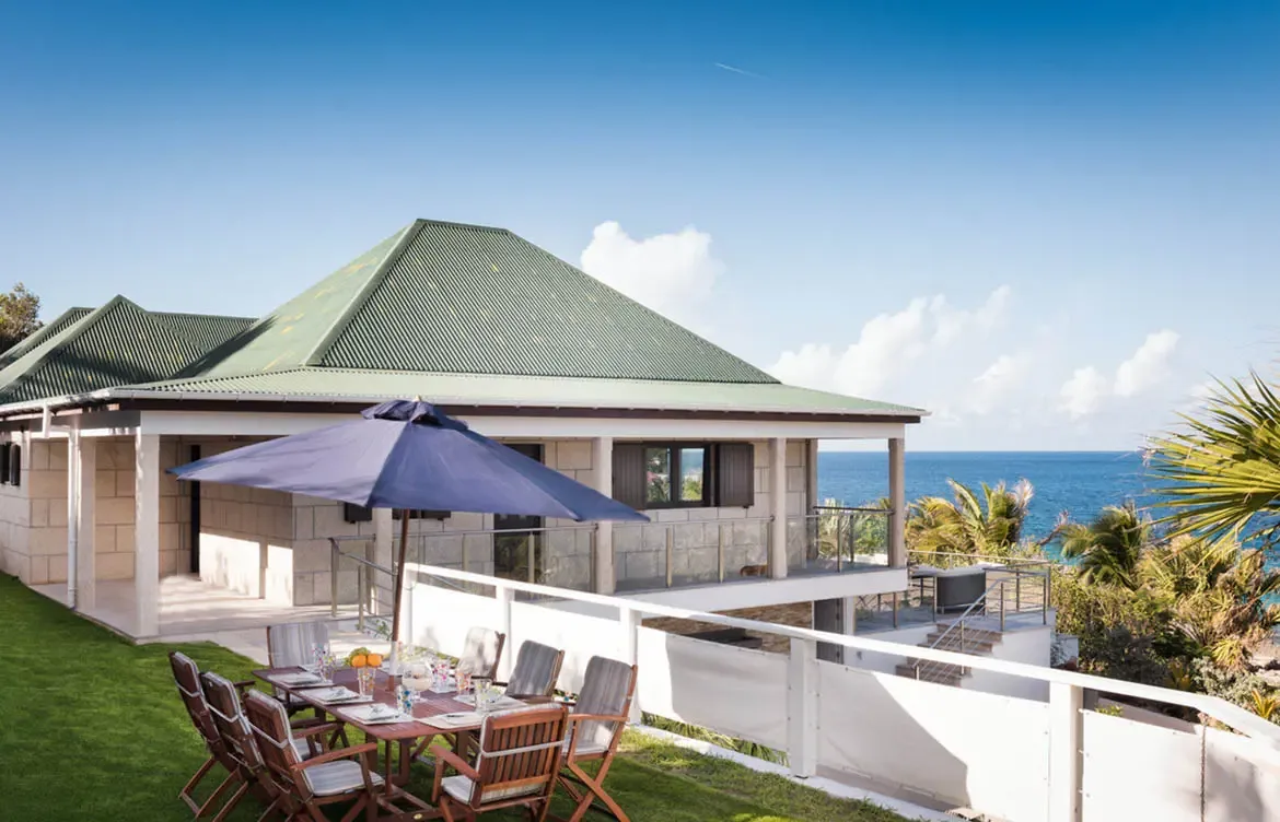 Savor gourmet meals with a view in the alfresco dining area, nestled in a lush garden setting overlooking the Caribbean Sea.