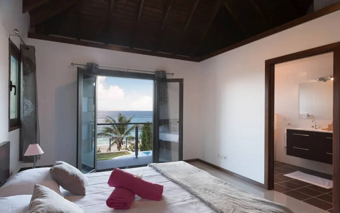 Retreat to a tranquil sanctuary where floor-to-ceiling glass doors open to a private balcony overlooking the pristine bay.