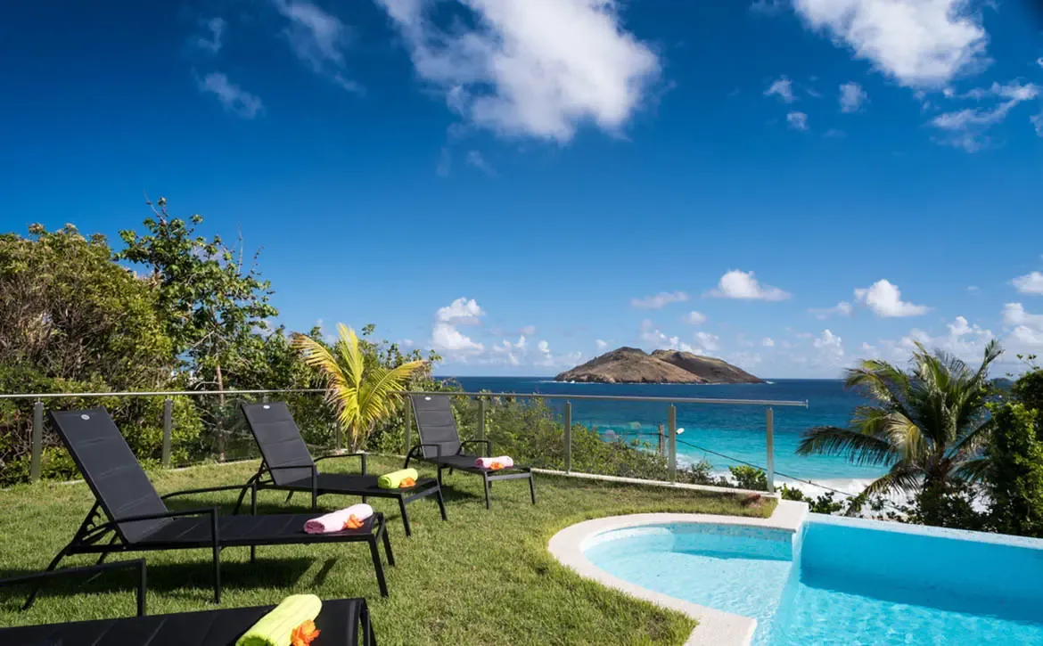 Bask in the St. Barths sun on comfortable poolside loungers, offering uninterrupted views of the sparkling ocean and distant islands.